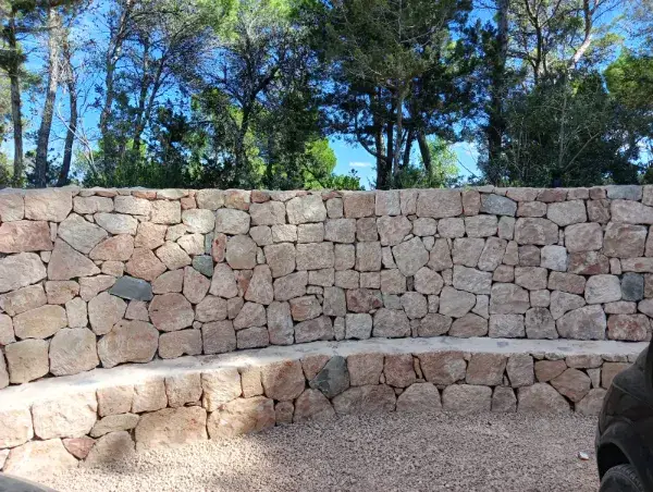 Rénovation de villa de luxe à Ibiza avec mur en pierre rustique intégré dans le paysage méditerranéen